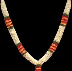 an old necklace with beads on it and a red, white, yellow and green bead