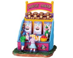 a carnival machine with two clowns on it's front and one girl standing in front