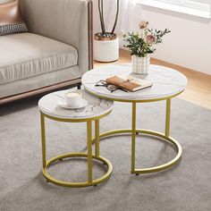 two tables sitting on top of a carpeted floor in front of a couch and window