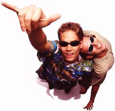 two men are pointing at the camera with their arms around each other while wearing sunglasses