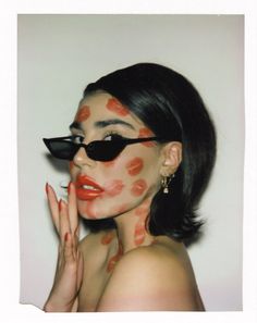 a woman with red lipstick on her face and black sunglasses