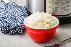 a red bowl filled with rice next to an instant pot