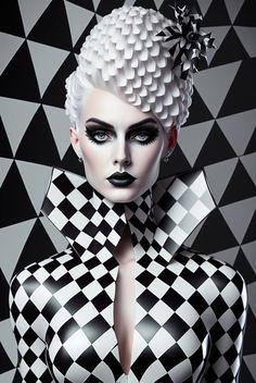 a woman with white hair and black makeup is dressed in checkered clothing, posing for the camera