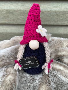 a crocheted gnome with a name tag on it