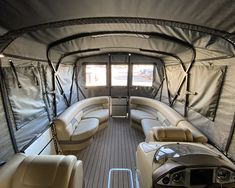 the inside of a boat with couches and windows