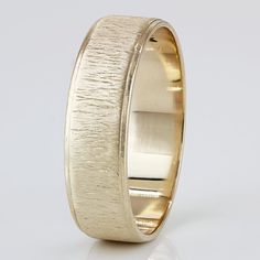 an image of a wedding ring that is yellow gold with a textured design on it