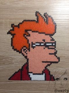 an image of a cartoon character made out of perforated beads on wood background