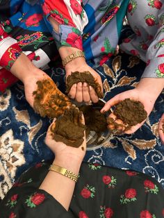 two women are holding mud in their hands