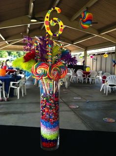 a tall glass vase filled with lots of candy