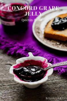 there is a small bowl with jelly in it on the table next to a slice of cake