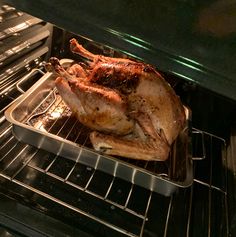 a roasted chicken is in an oven with the door open and it's ready to be cooked