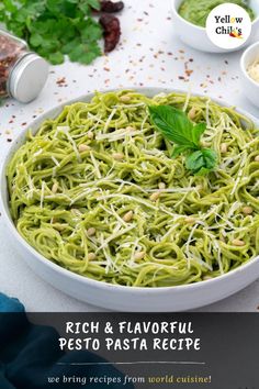 a bowl filled with pesto pasta and garnished with parsley