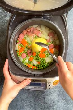 someone using a spoon to stir food in a pot on top of a digital scale