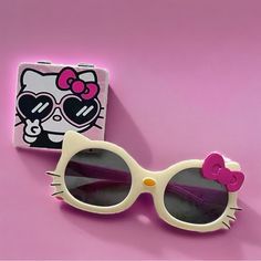 a hello kitty sunglasses and box on a pink background