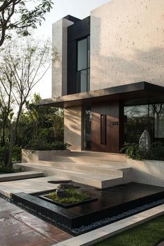 a modern house with water feature in the front yard and steps leading up to it