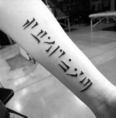 a black and white photo of a person's arm with roman numerals on it