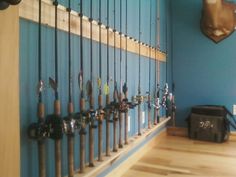 there are many fishing rods lined up on the wall in front of the fish hooks