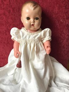 a baby doll is wearing a white dress