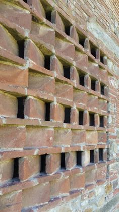 an old brick wall with holes in it