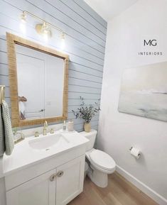 a bathroom with white walls and wood flooring is featured in the magazine mc interiors