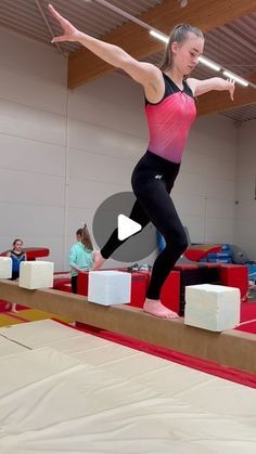 a woman standing on top of a balance beam