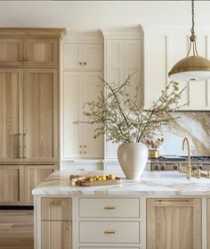 a large kitchen with marble counter tops and wooden cabinetry, along with an island in the middle