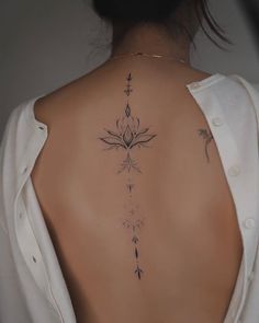 the back of a woman's neck with tattoos on it