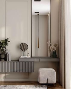 a mirror sitting on top of a wooden table next to a white chair and vase