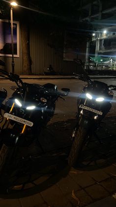 two motorcycles parked next to each other at night