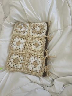 a crocheted pillow is laying on a bed