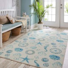 a blue and white area rug with sea shells on it in front of a door