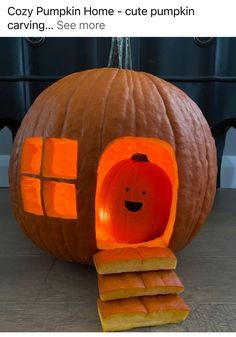 a pumpkin shaped like a house with a carved face and windows on the outside, sitting in front of a pile of cut out pieces of wood