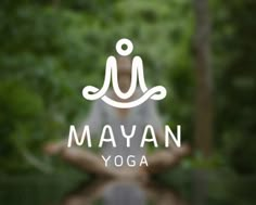 a person sitting in the middle of a forest with their hands out and yoga logo over them