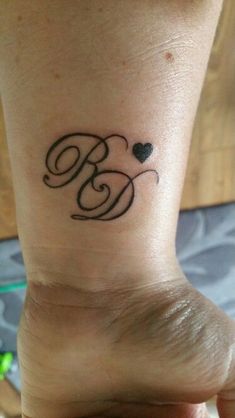 a woman's foot with a small tattoo on the ankle that reads b and heart