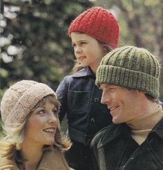 two adults and a child wearing knitted hats in front of trees with the caption knitting for the family