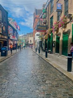 a cobblestone street lined with shops and people