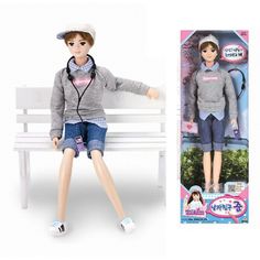 a doll sitting on top of a white bench next to a package of clothes and shoes