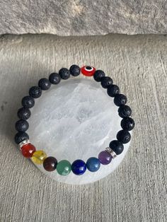 Beautiful Chakra bracelet made with lava beads and a red eye bead. Chakra beads are natural stone  Size 6.5/7 Chakra Beads, Lava Beads, Body Balance, Red Eye, Chakra Bracelet, 7 Chakras, Lava Bead, Eye Bracelet, Evil Eye Bracelet