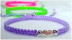 three different colored bracelets with silver beads and two hearts on each side, one is purple