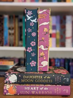 two books stacked on top of each other in front of a book shelf filled with books