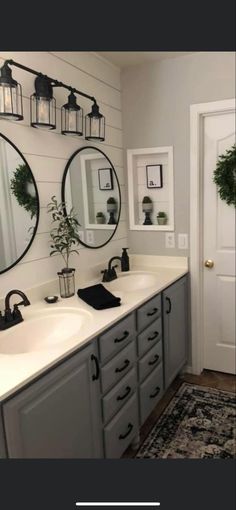 a bathroom with two sinks, mirrors and plants on the wall above them is featured in this post