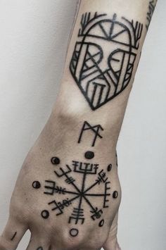 a person's hand with a tattoo on it, and an arrow in the middle