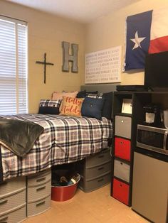 a bed room with a neatly made bed next to a refrigerator and microwave ovens