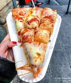 a person holding up a paper plate with several slices of pizza on top of it