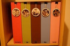 four different colored bookmarks with pictures on them in a wooden shelf next to a wall