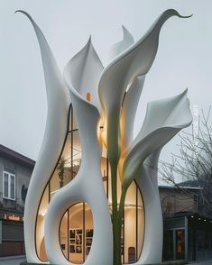 a large white flower sculpture sitting in front of a building