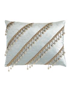 a decorative pillow with beads and chains on it