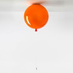 an orange balloon is suspended from the ceiling