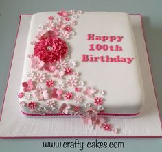 a birthday cake decorated with pink flowers and white frosting