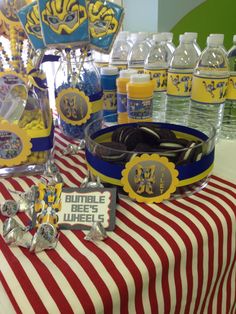 a table topped with lots of bottles of water and plates filled with cake next to each other